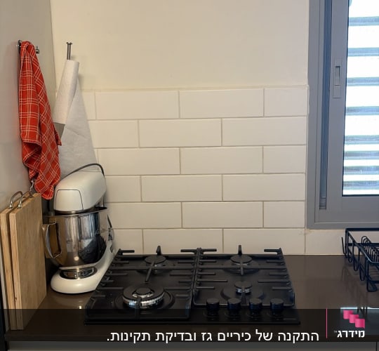 כיריים גז שחורות מותקנות על משטח עבודה במטבח מודרני